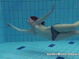 Redheaded söpöläinen uinti alaston sisään the altaan